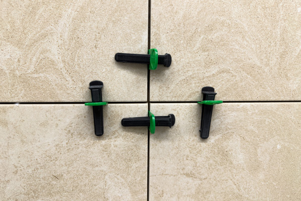 tile spacers arranged on a tiled surface demonstrating alignment and spacing for tile installation three tile spacers